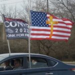 A US flag with a Christian cross drawn over it